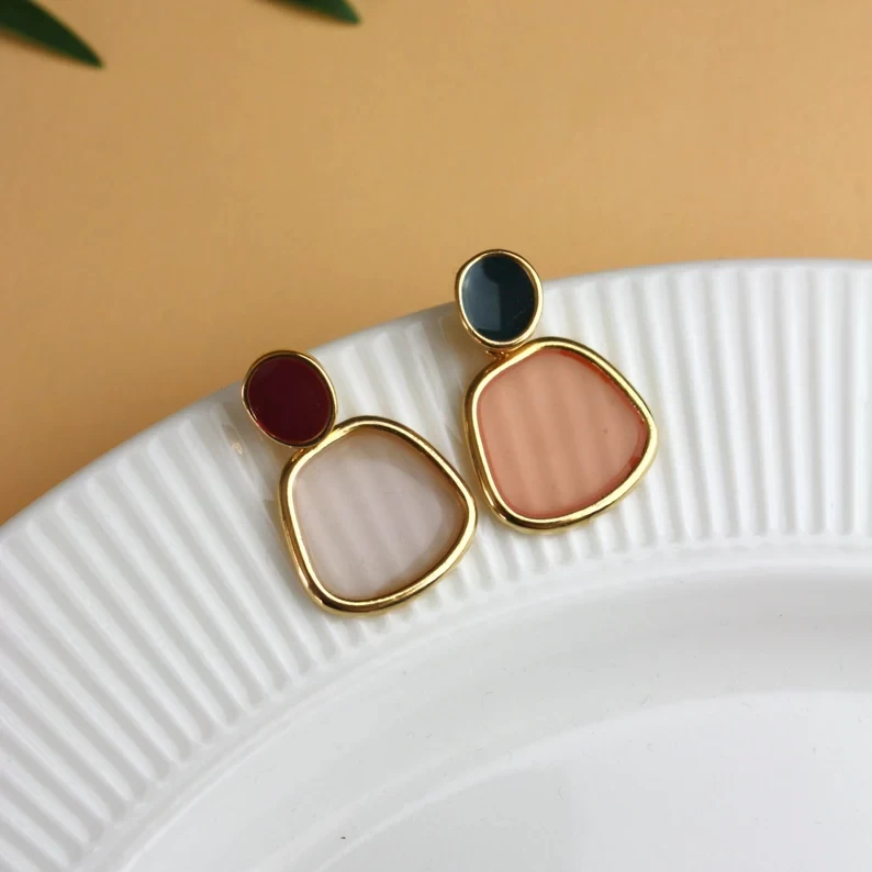 Asymmetrical stud earrings with abstract pendants